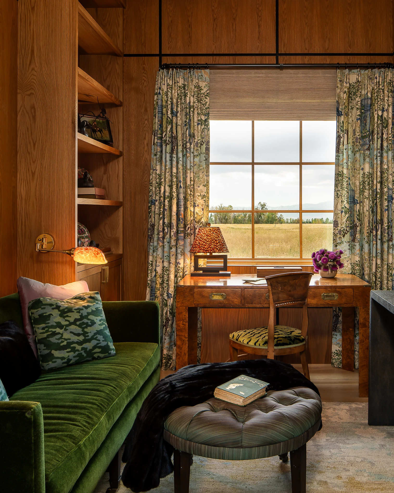 Wood-paneled den with a green velvet sofa and a desk facing the window — interior design photography Driggs Idaho, River's Edge